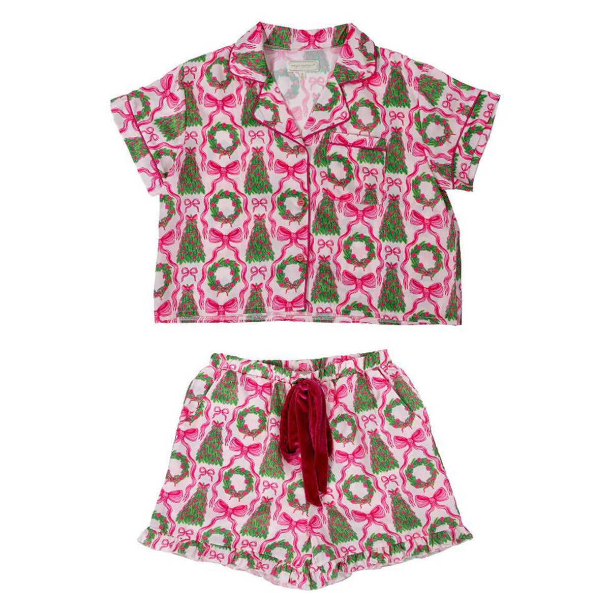 Pink pajama set with green trees and red bows on a white background
