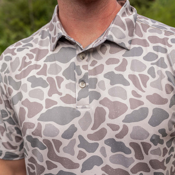 Close-up of a camo polo shirt with a blurred green background