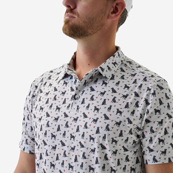 Man wearing a patterned shirt with dog designs on a white background