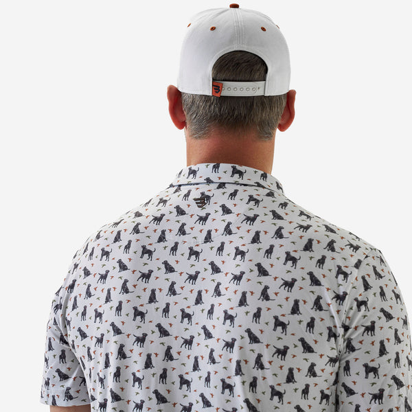 Man wearing a white cap and a shirt with black dog pattern on a white background