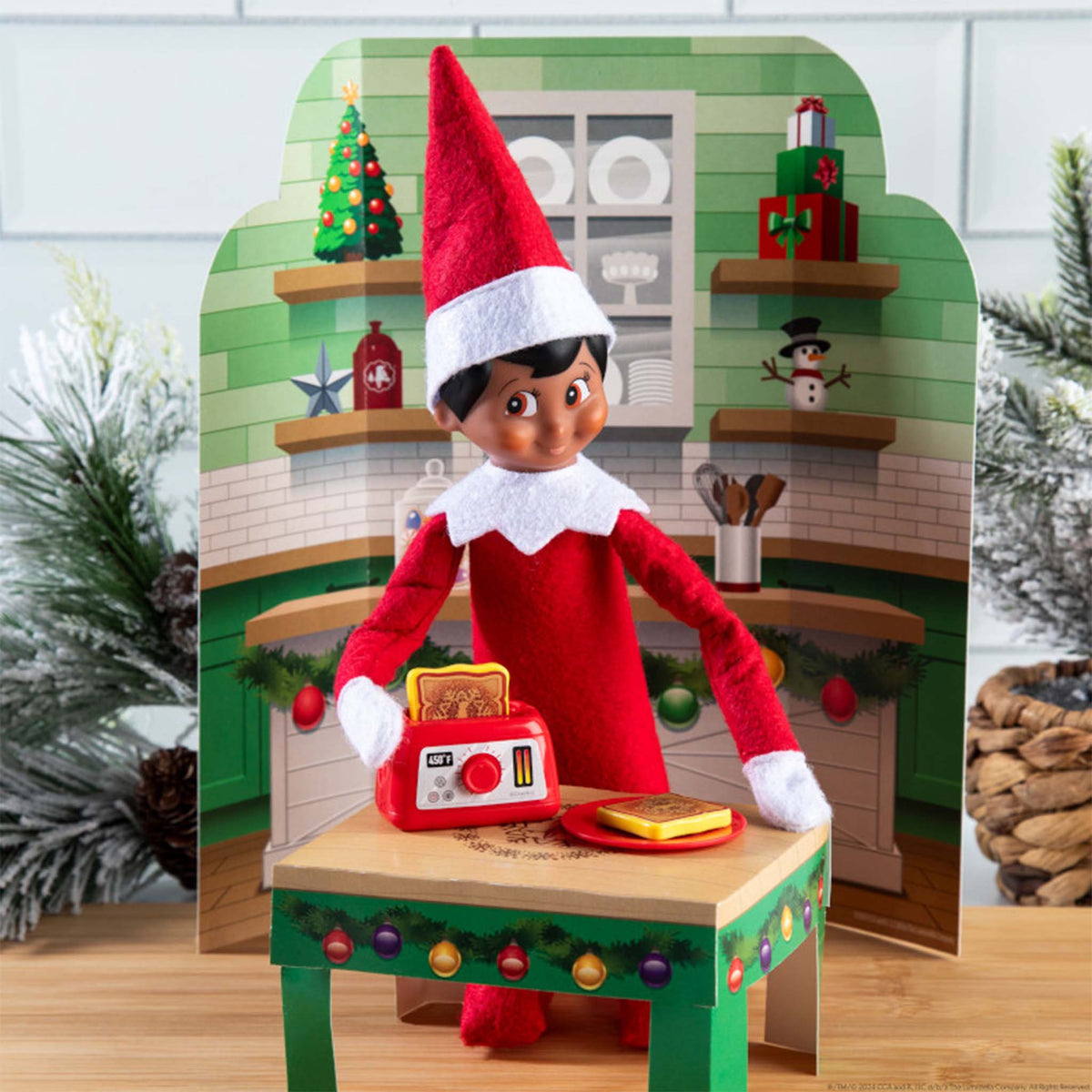 Elf on the Shelf with a toaster and toast in a decorated room