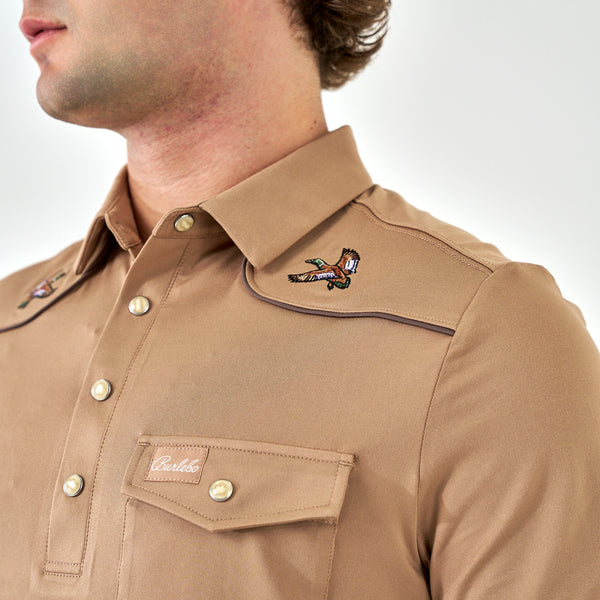 Close-up of a brown shirt with embroidered designs on a white background