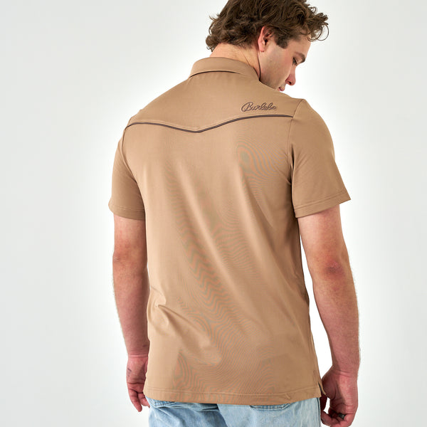 Man wearing a beige polo shirt with a brand logo on a white background