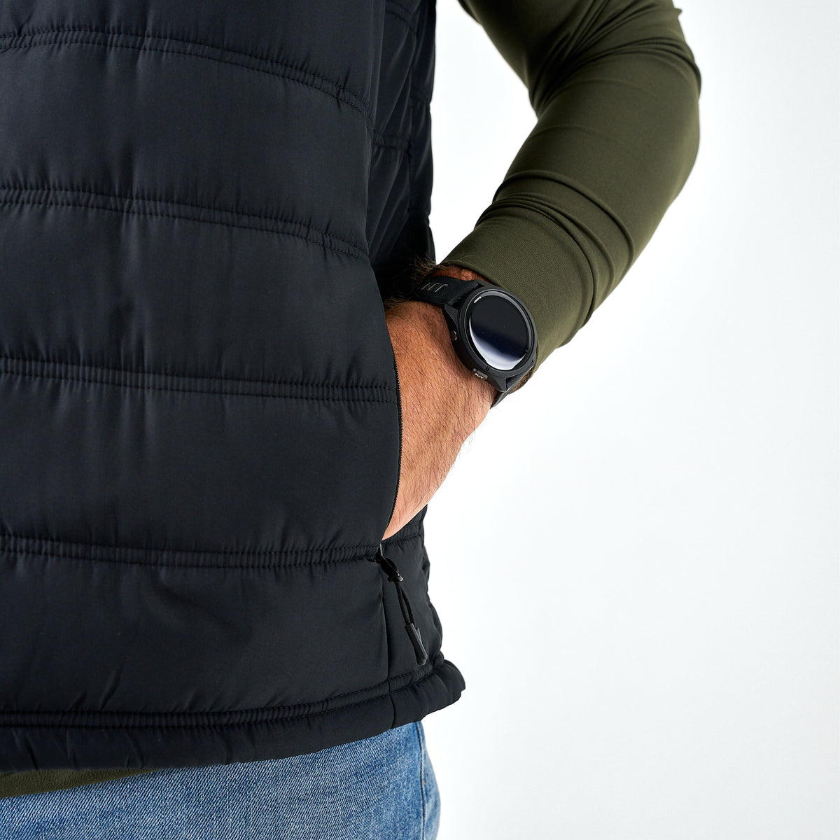 Person wearing a black puffer vest with a white background
