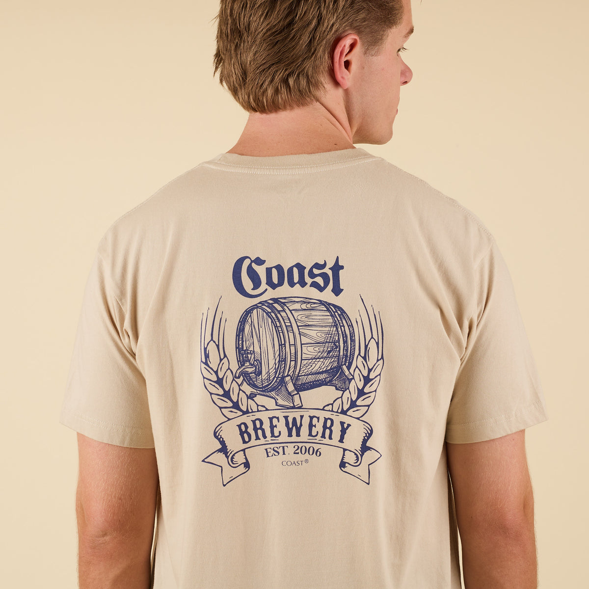 Close-up of COAST Beer Barrel tee back graphic featuring illustrated barrel with wheat and banner text.
