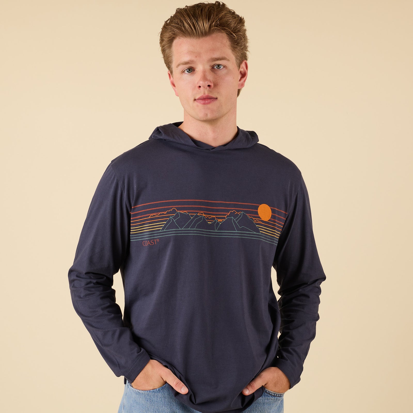 Front of COAST Mountains Hoodie Tee in navy featuring multicolor mountain and sunset chest graphic.