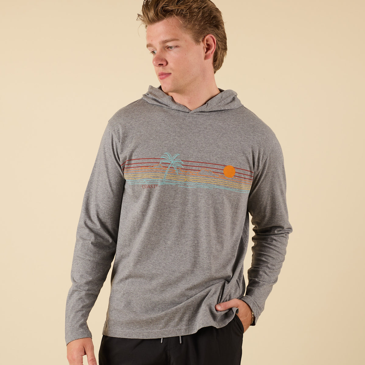 Front view of COAST Palm Sunset Hooded Performance Tee in heather grey with retro stripe, palm tree, and sunset graphic across chest.