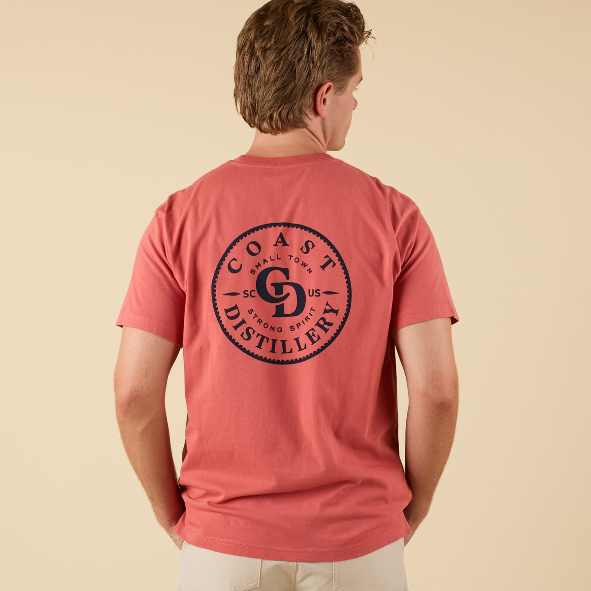 COAST Distillery short sleeve pocket t-shirt in red with large circular logo graphic on back.