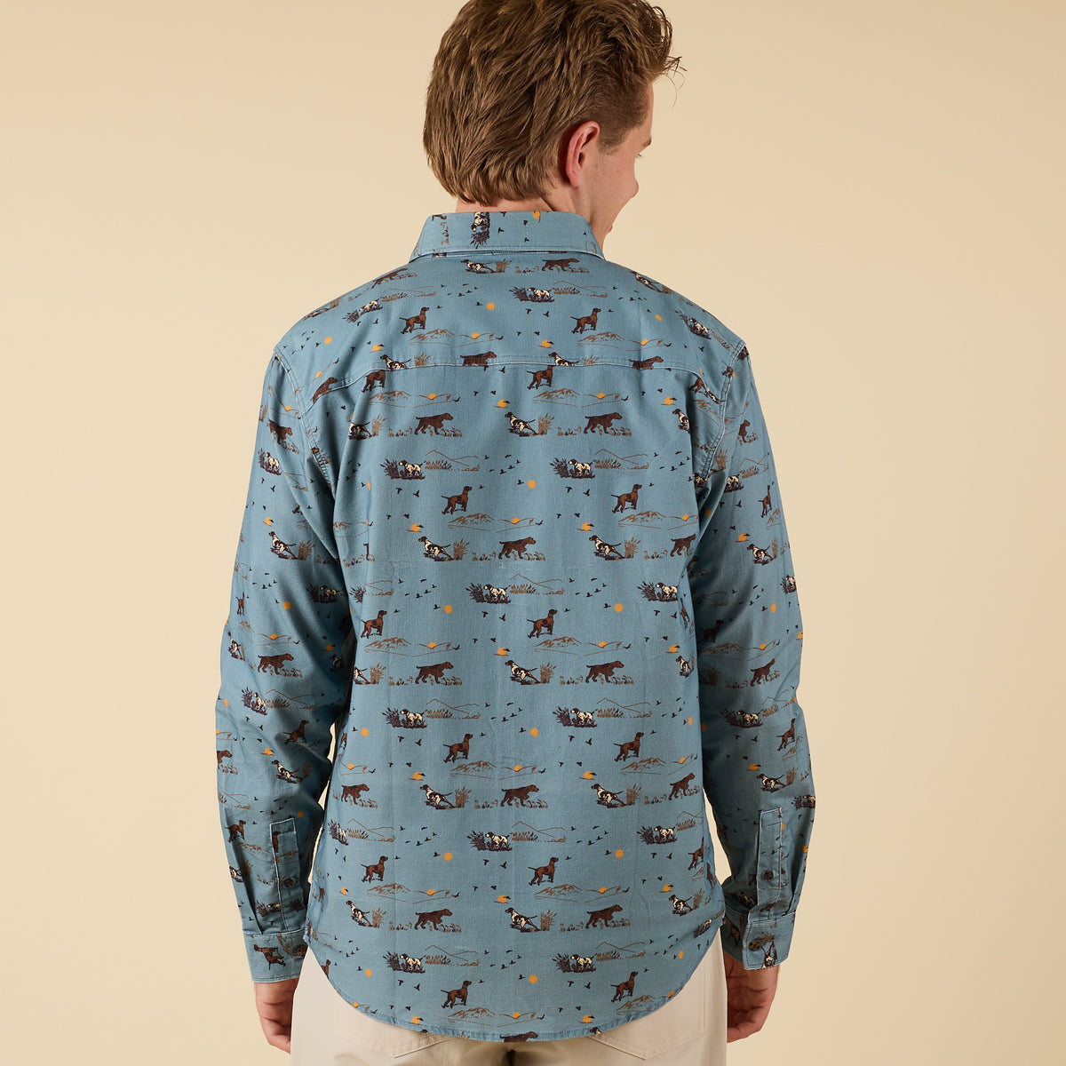 Back view of man wearing blue hunting dog print button-down shirt