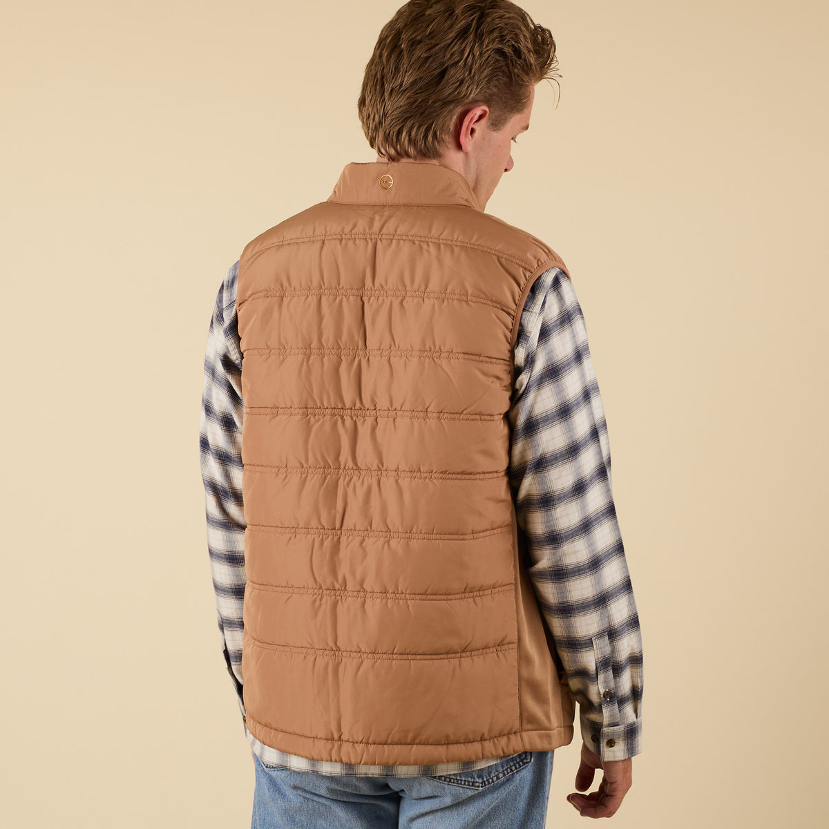 Back view of Coast Apparel Foredeck Vest in Chestnut on model wearing plaid shirt