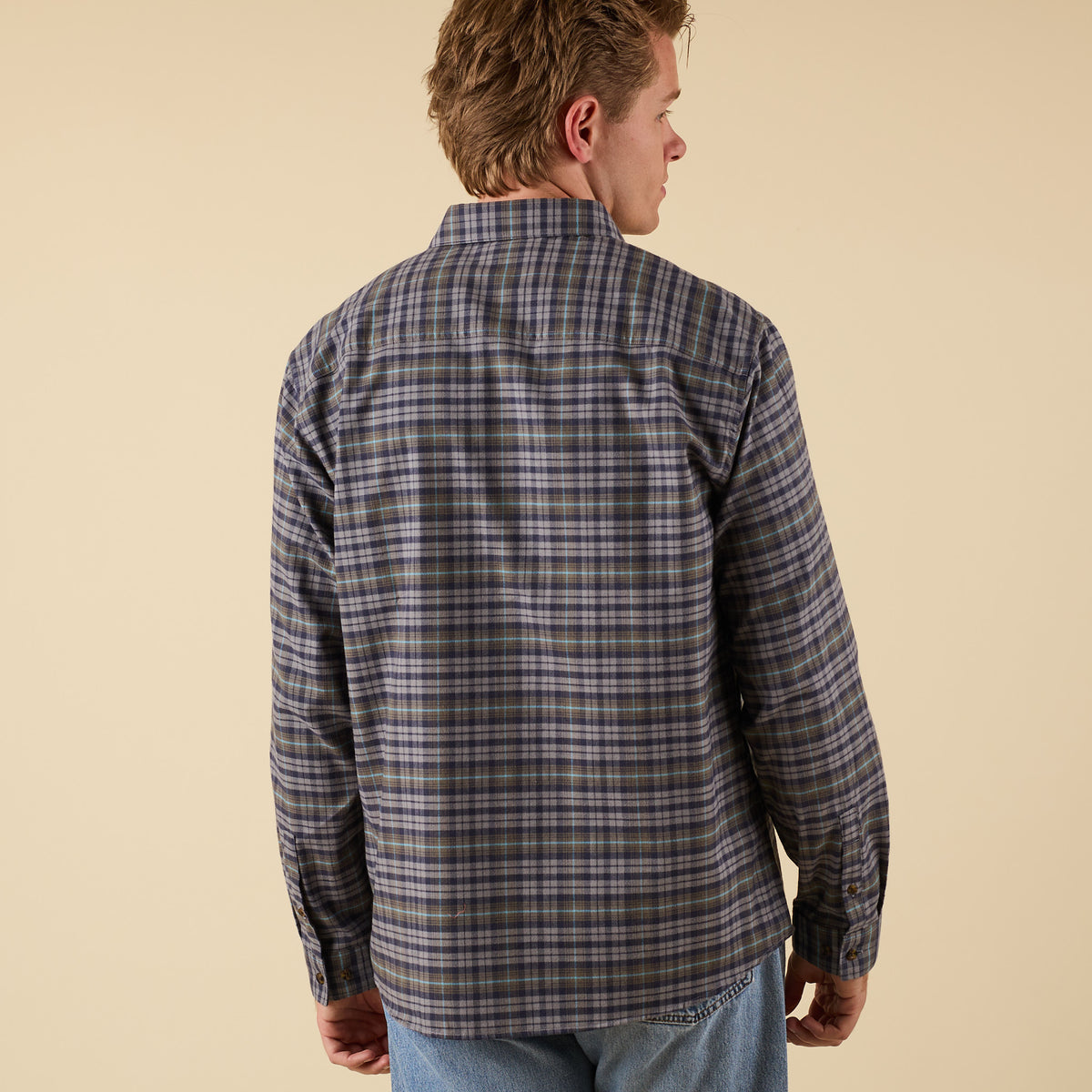 Man wearing a plaid shirt on a beige background