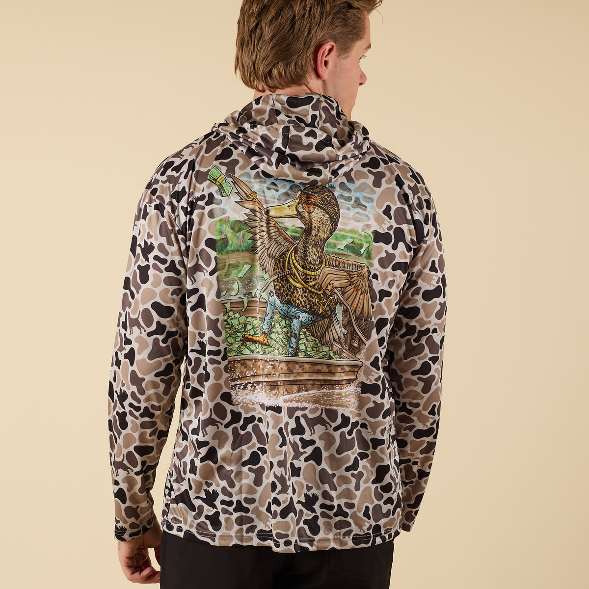 Man wearing a camo performance hoodie with a duck on the back.