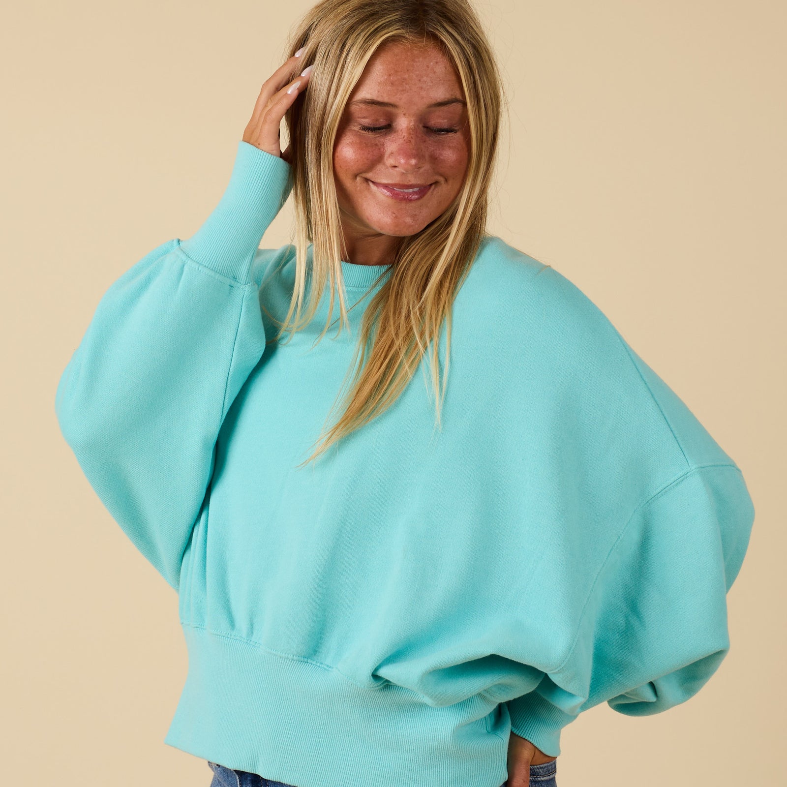 Beach mint Youngstown crewneck sweatshirt shown in side angle with oversized sleeves.