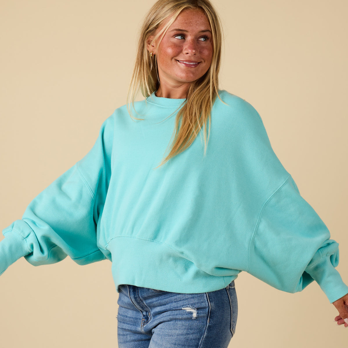 Beach mint Youngstown crewneck sweatshirt shown in side angle with oversized sleeves.