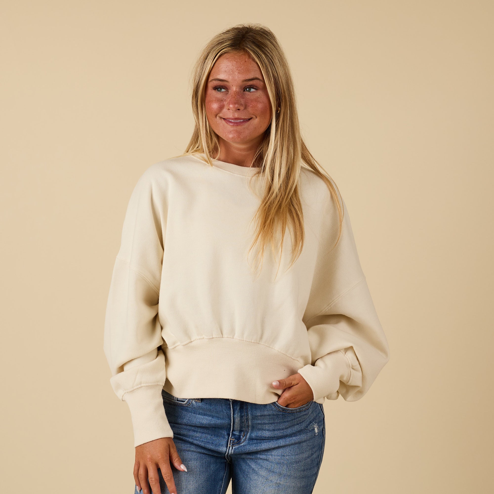 Ivory Youngstown crewneck sweatshirt with relaxed fit and ribbed hem, modeled from the front.