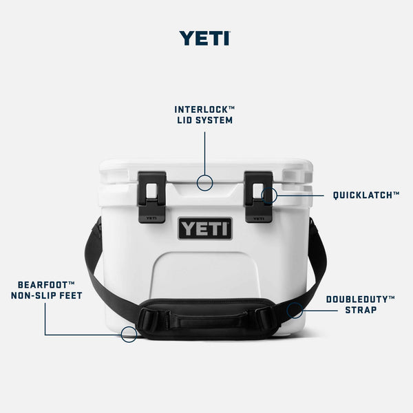 YETI Roadie 15 hard cooler in white with labeled features including Interlock lid system, Quicklatch closures, Doubleduty shoulder strap, and Bearfoot non-slip feet.