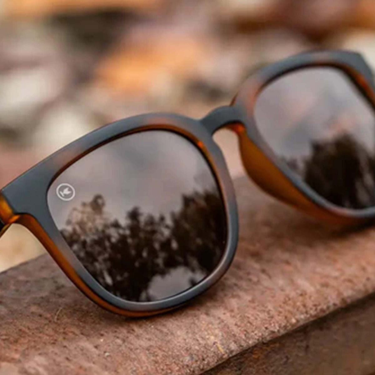 Sunglasses with reflective lenses on a textured surface