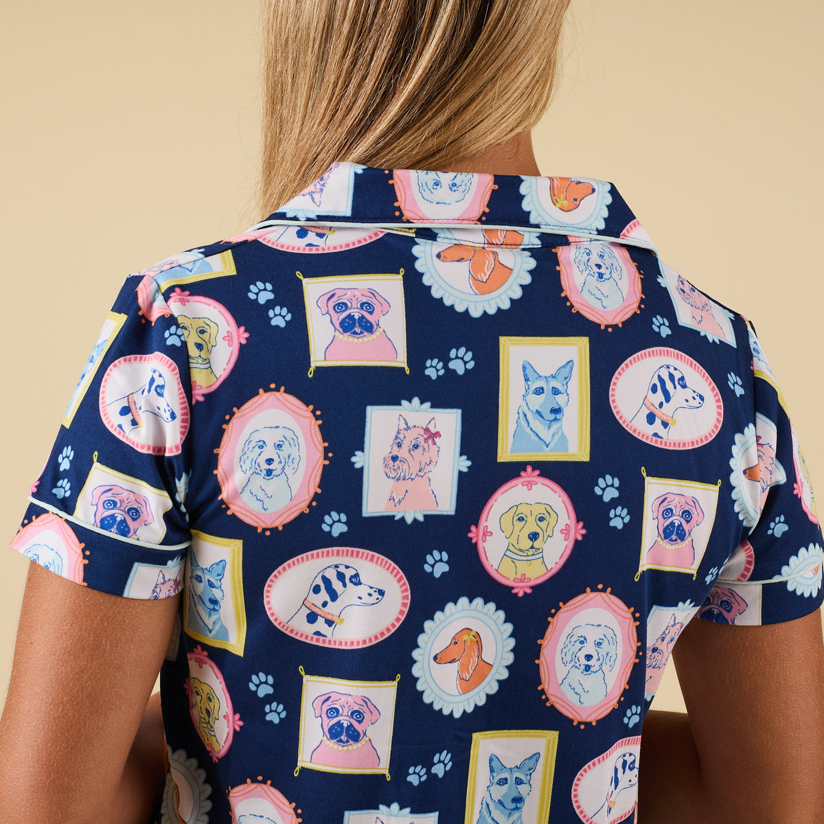Back view of blue pajama top with multicolor dog portrait print and fold-over collar.