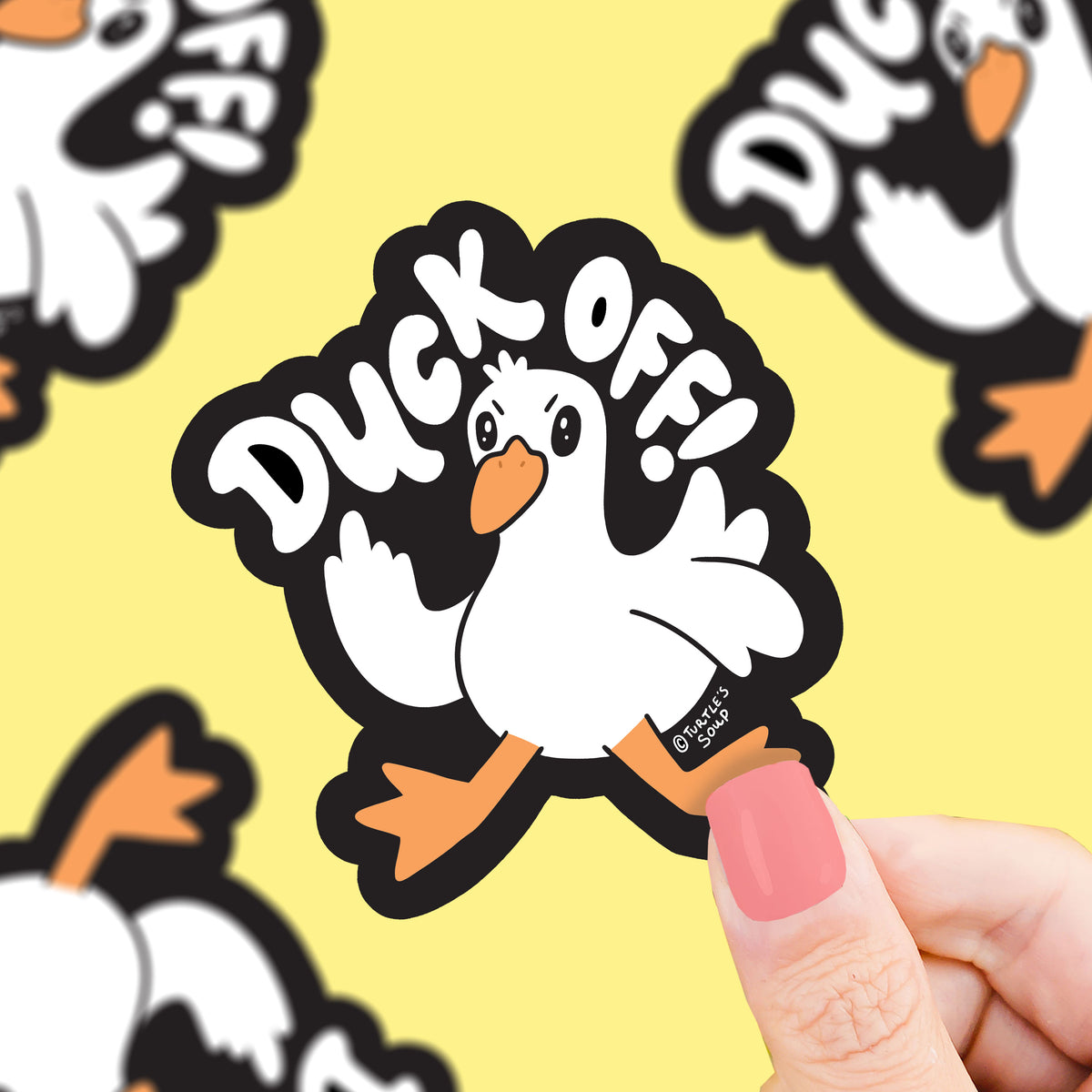 Sticker with a duck design and 'Duck Off!' text held by a hand against a yellow background with more duck stickers.