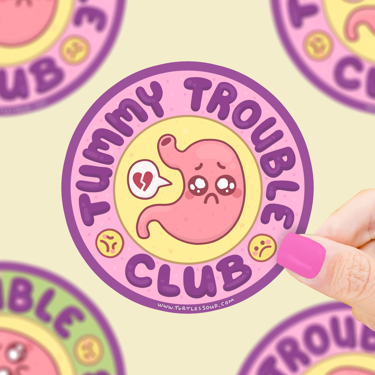 Sticker with 'Tummy Trouble Club' design held by a hand against a matching background