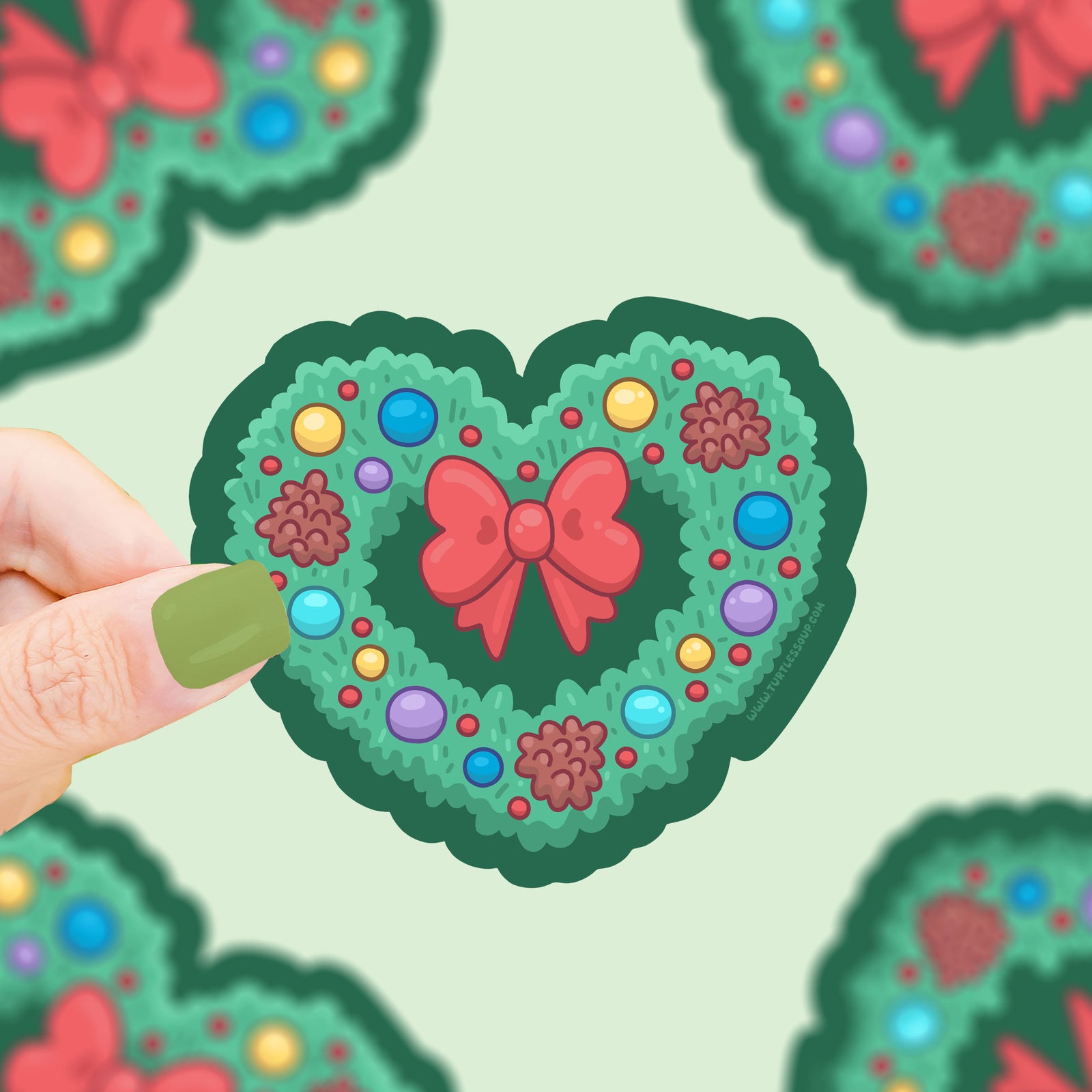Heart-shaped decorative sticker with a red bow and colorful polka dots on a light green background.