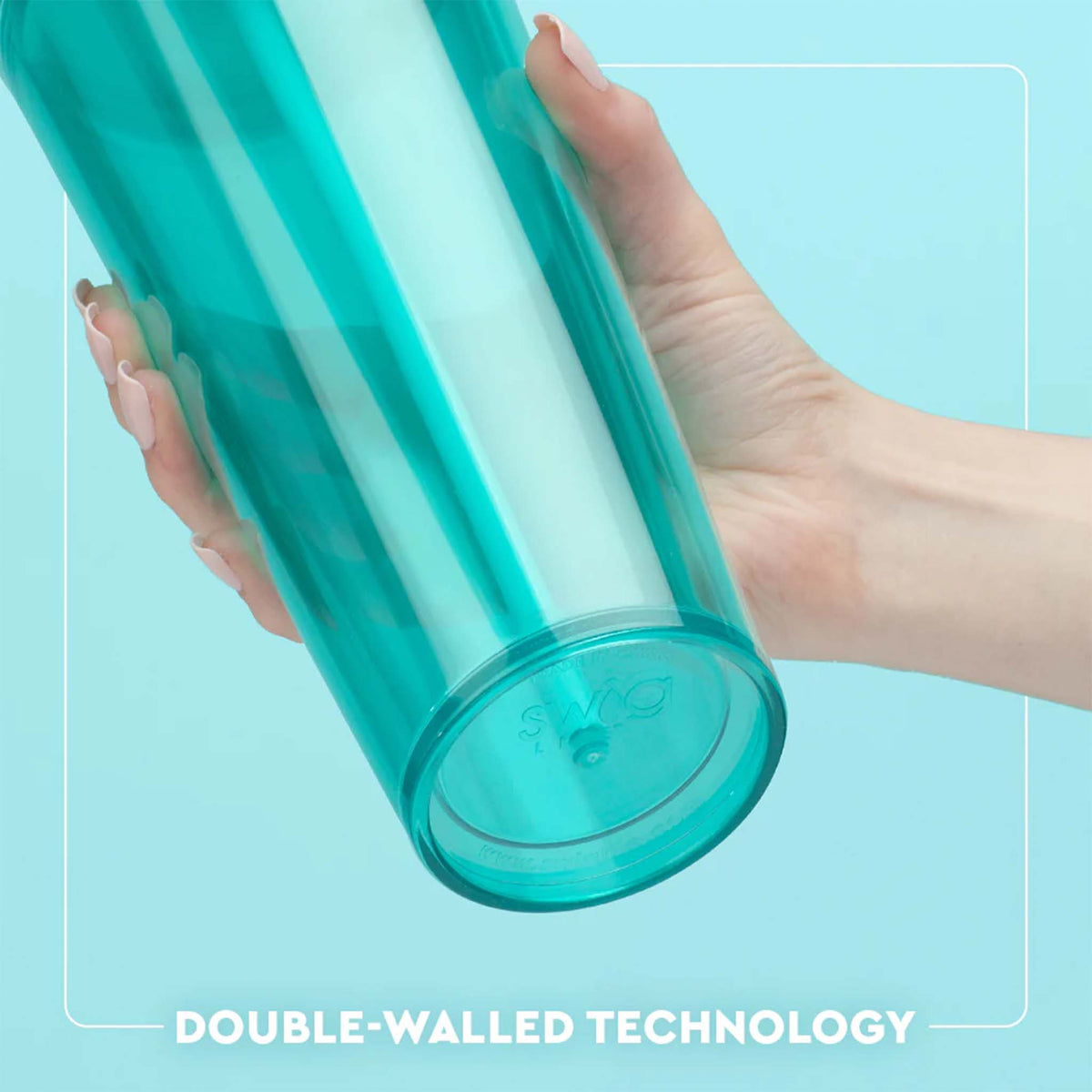 Hand holding a teal double-walled tumbler against a light blue background