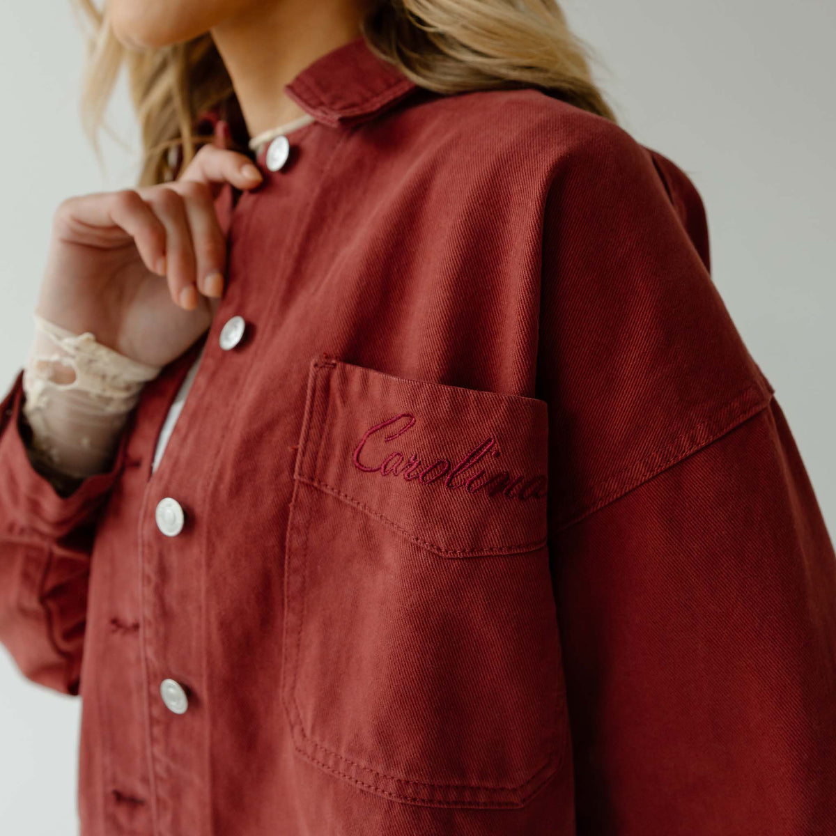 Maroon cropped jacket with embroidered “Carolina” text on front chest pocket.