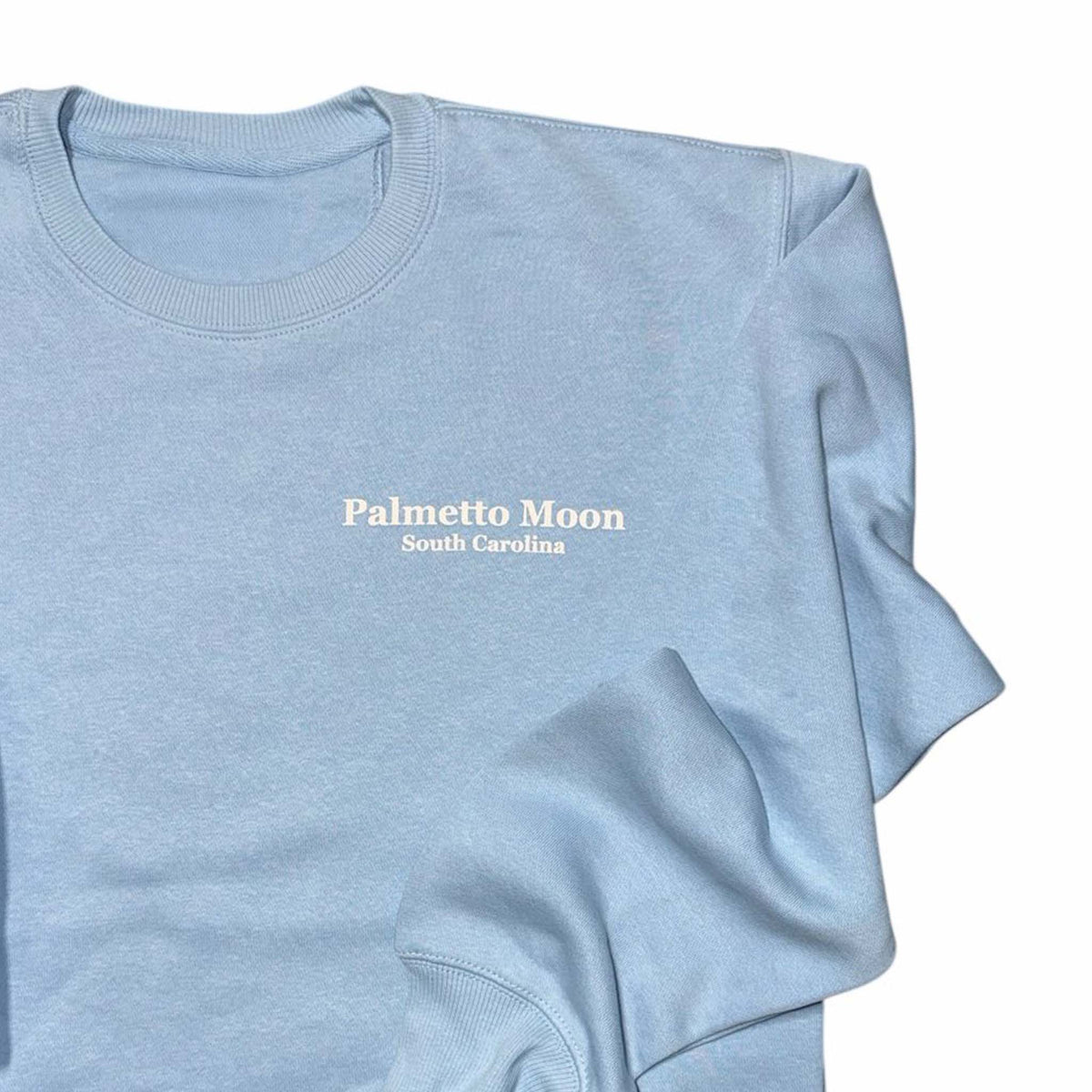 Clear Sky | Light blue sweatshirt with 'Palmetto Moon South Carolina' text on a white background