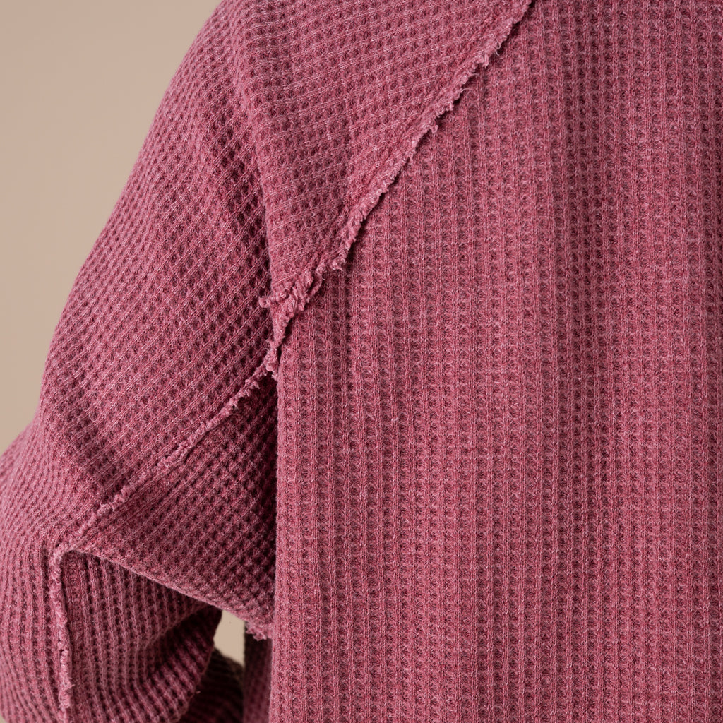 Close-up of a textured pink garment on a beige background
