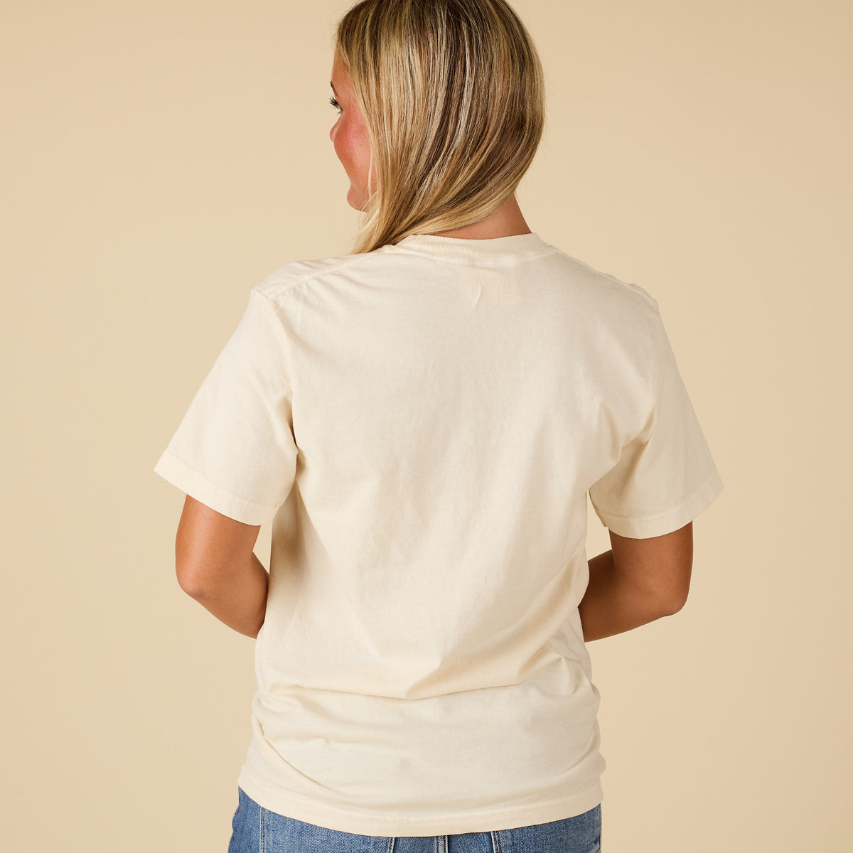 Back view of a women’s ivory short sleeve t-shirt shown plain with no graphics.