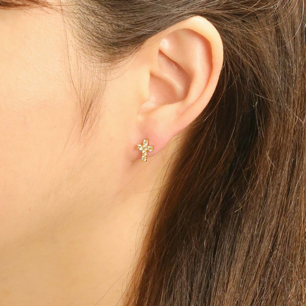 Do everything in love Diamond Cross Stud Earrings, Close-up of a woman wearing small gold cross stud earrings with clear round crystals.