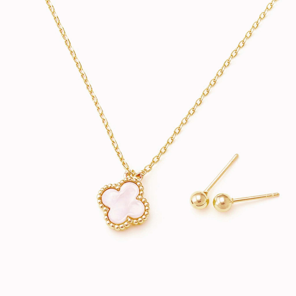Gold necklace with a pink clover-shaped pendant shown beside matching gold ball stud earrings on a light background.