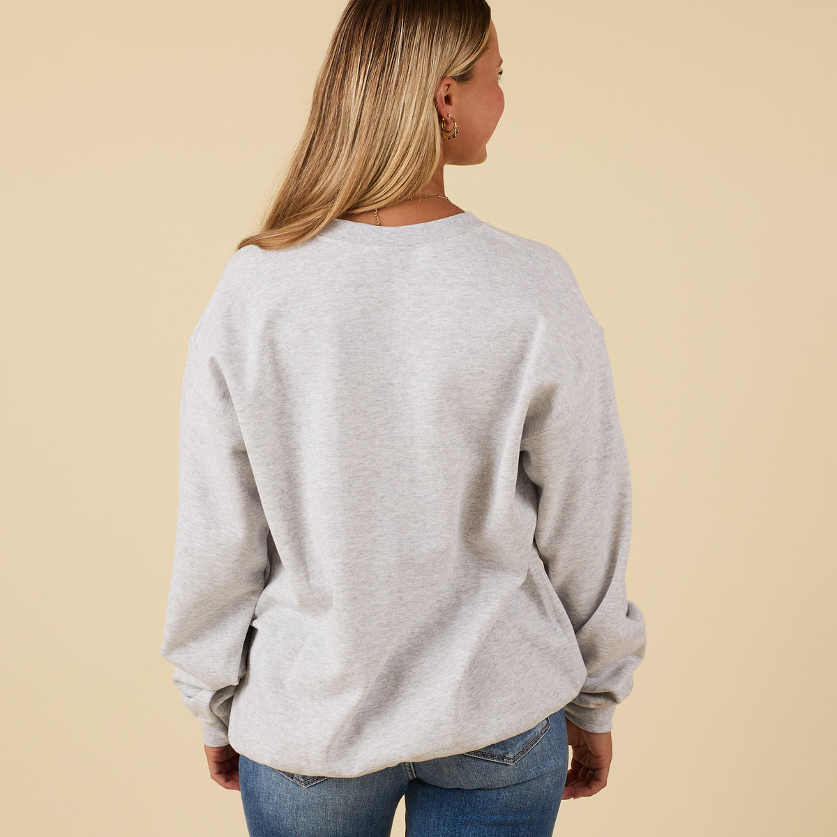 Back view of plain light grey crewneck sweatshirt with relaxed fit.
