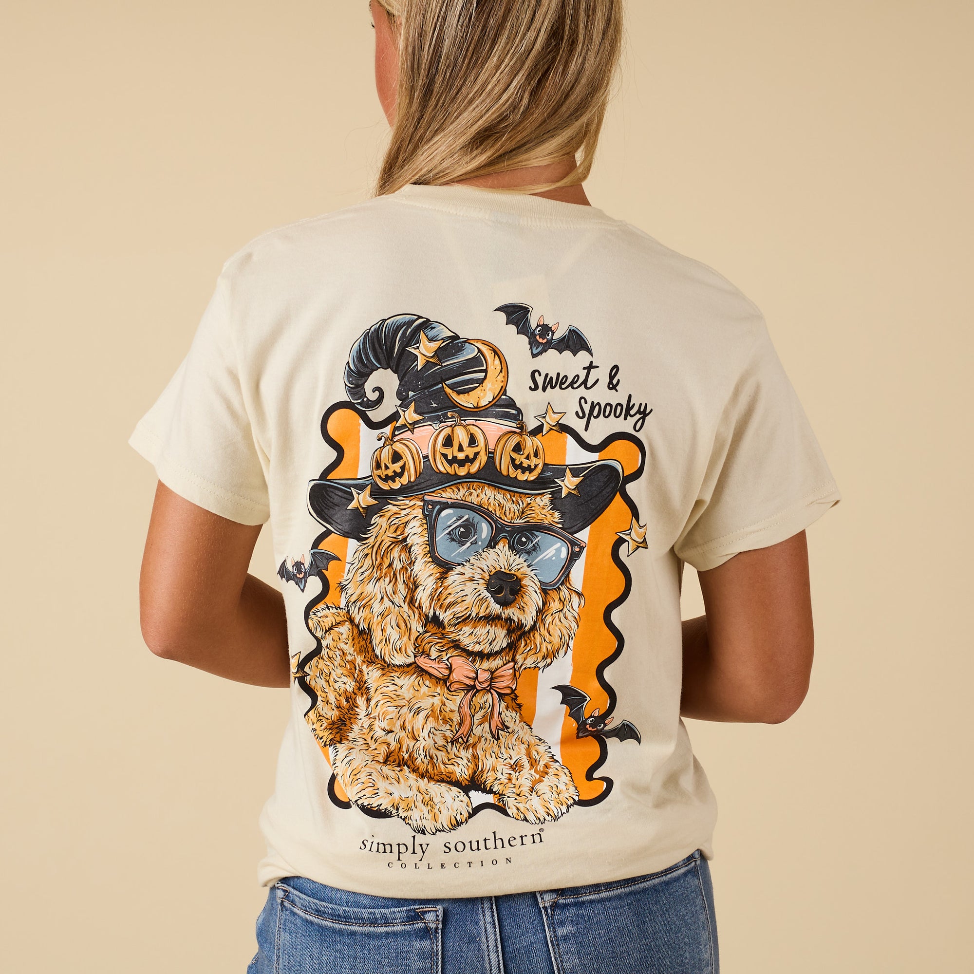 Back of ivory Simply Southern short sleeve tee with doodle dog wearing witch hat decorated with pumpkins, moon, bats, and “Sweet & Spooky” text.