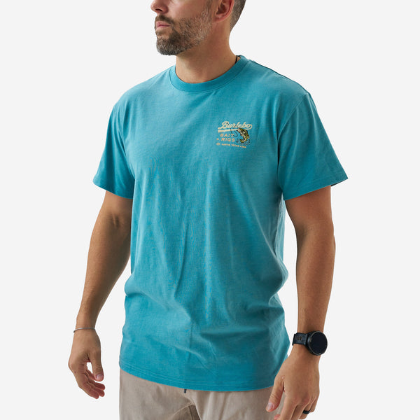 Angled front view of a male model wearing a teal short sleeve Burlebo graphic t-shirt with a small chest print and crew neckline.