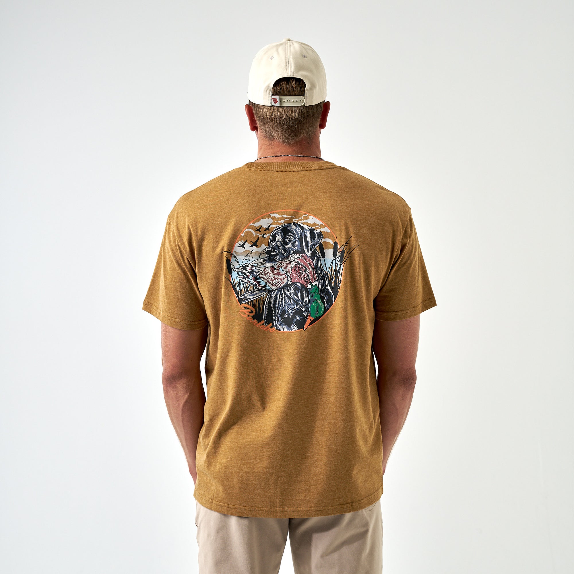 Back view of light brown Burlebo tee featuring a black lab holding a duck in hunting scene.