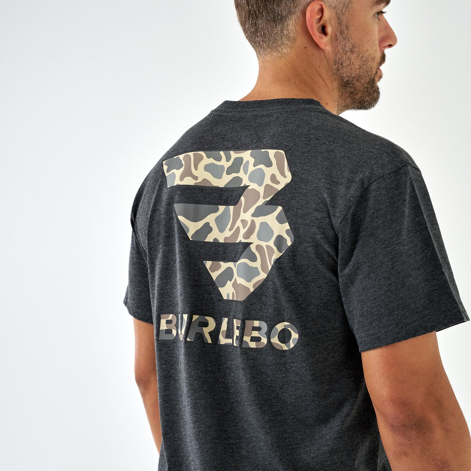 Back view of a dark charcoal short sleeve t-shirt with a large light brown camo Burlebo logo graphic.