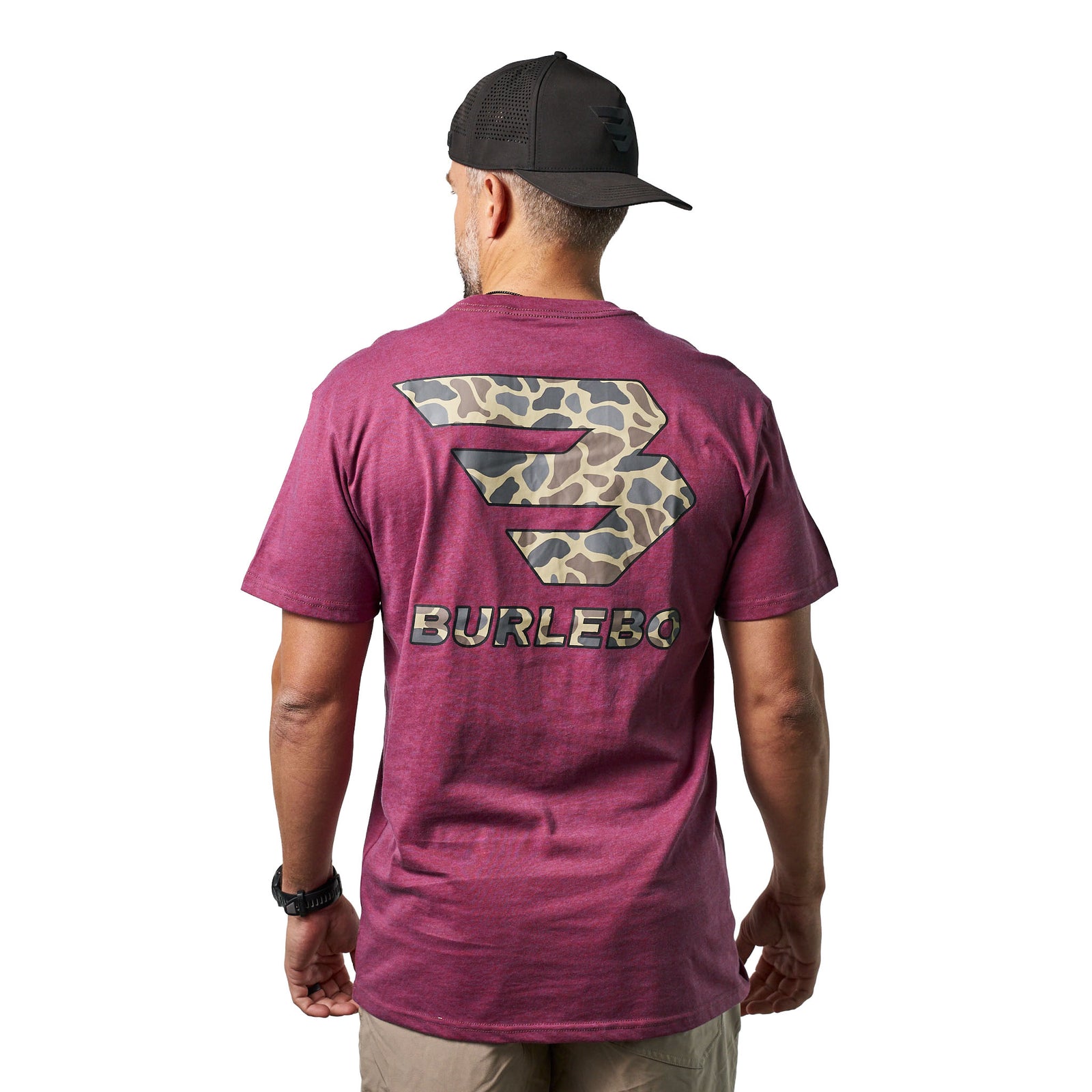 Rear full-body view of a male model wearing a heather maroon short sleeve Burlebo t-shirt with large camouflage logo on the back paired with khaki shorts.