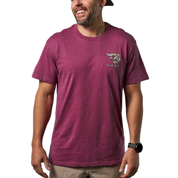 Front view of a male model wearing a heather maroon short sleeve Burlebo t-shirt with a small camouflage logo on the chest.