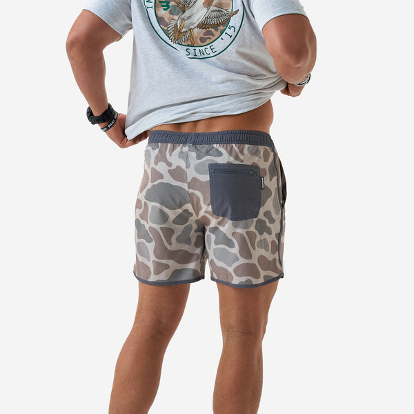 Back view of Burlebo 5 Inch Swim Shorts in Jumbo Deer Camo worn by a man in front of a white backdrop