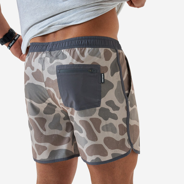 Close up of the zippered pocket on the Burlebo 5 Inch Swim Shorts in Jumbo Deer Camo worn by a man in front of a white backdrop
