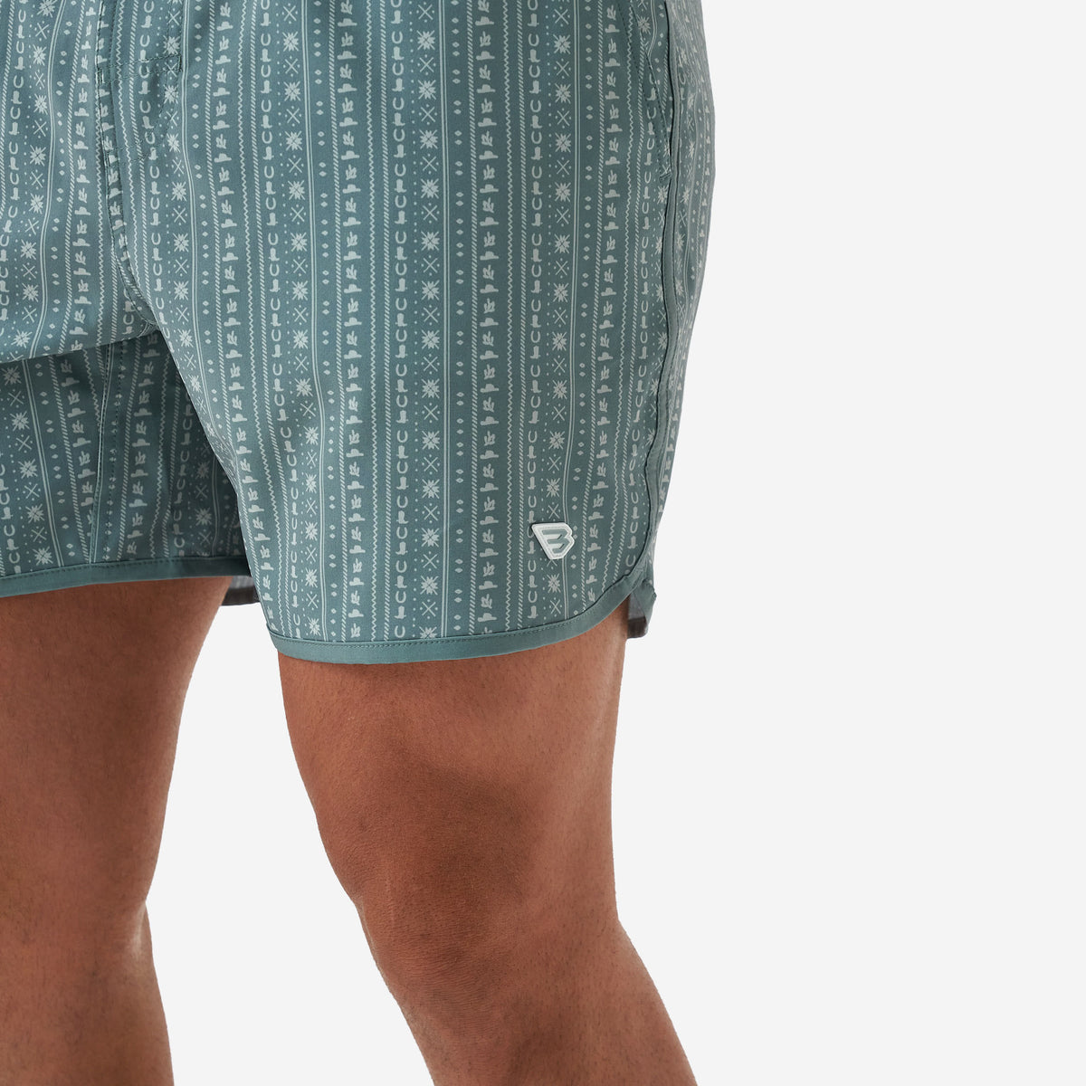 Man wearing sage green patterned Burlebo shorts in front of a white background