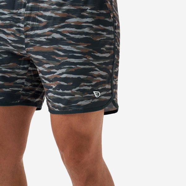Man wearing Burlebo 5 Inch Lined Swim Shorts in Tiger Wetland camo pattern on a white backdrop.