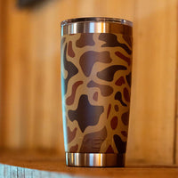 Camouflage-patterned tumbler on a wooden surface