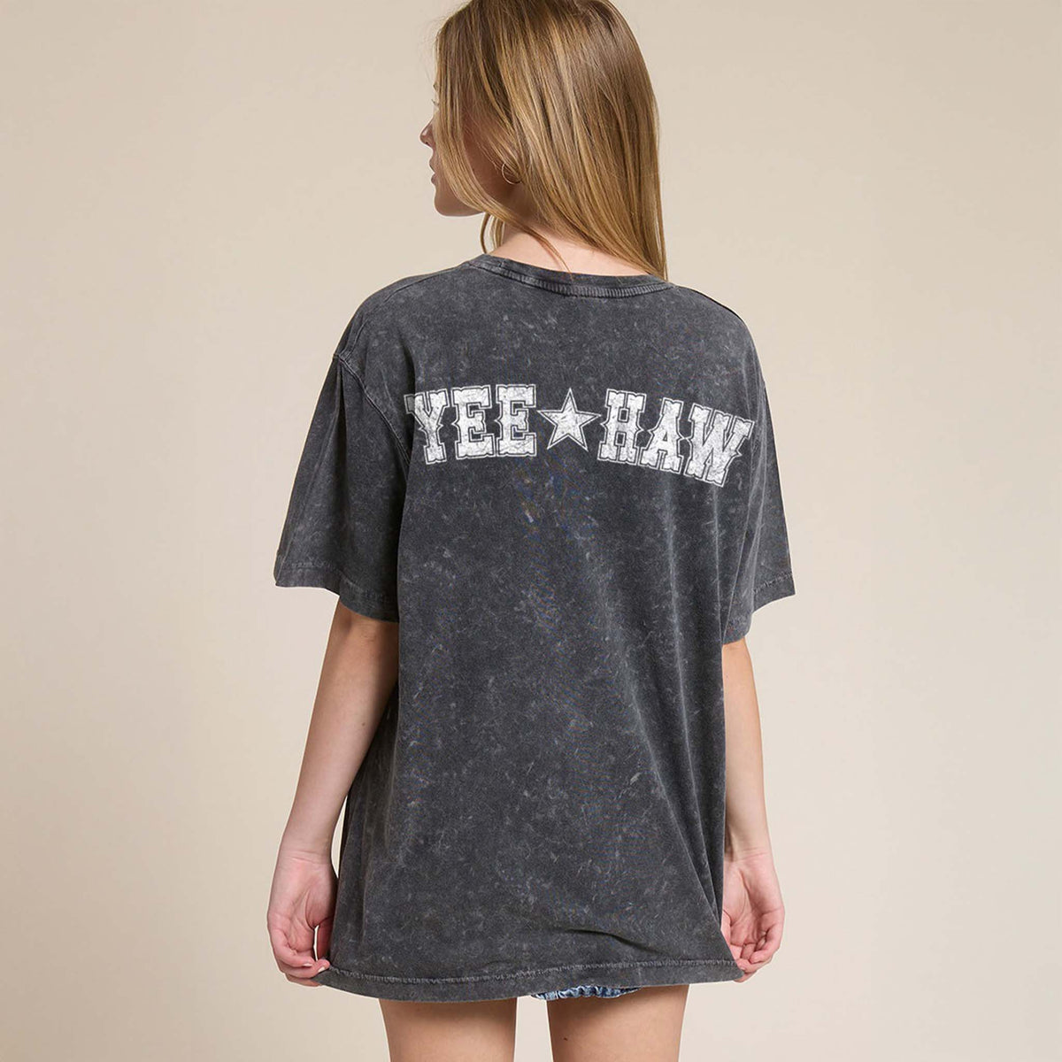 Black washed oversized tee with a distressed camo longhorn skull on the front and large white Western text reading 'YEE ★ HAW' across the back.