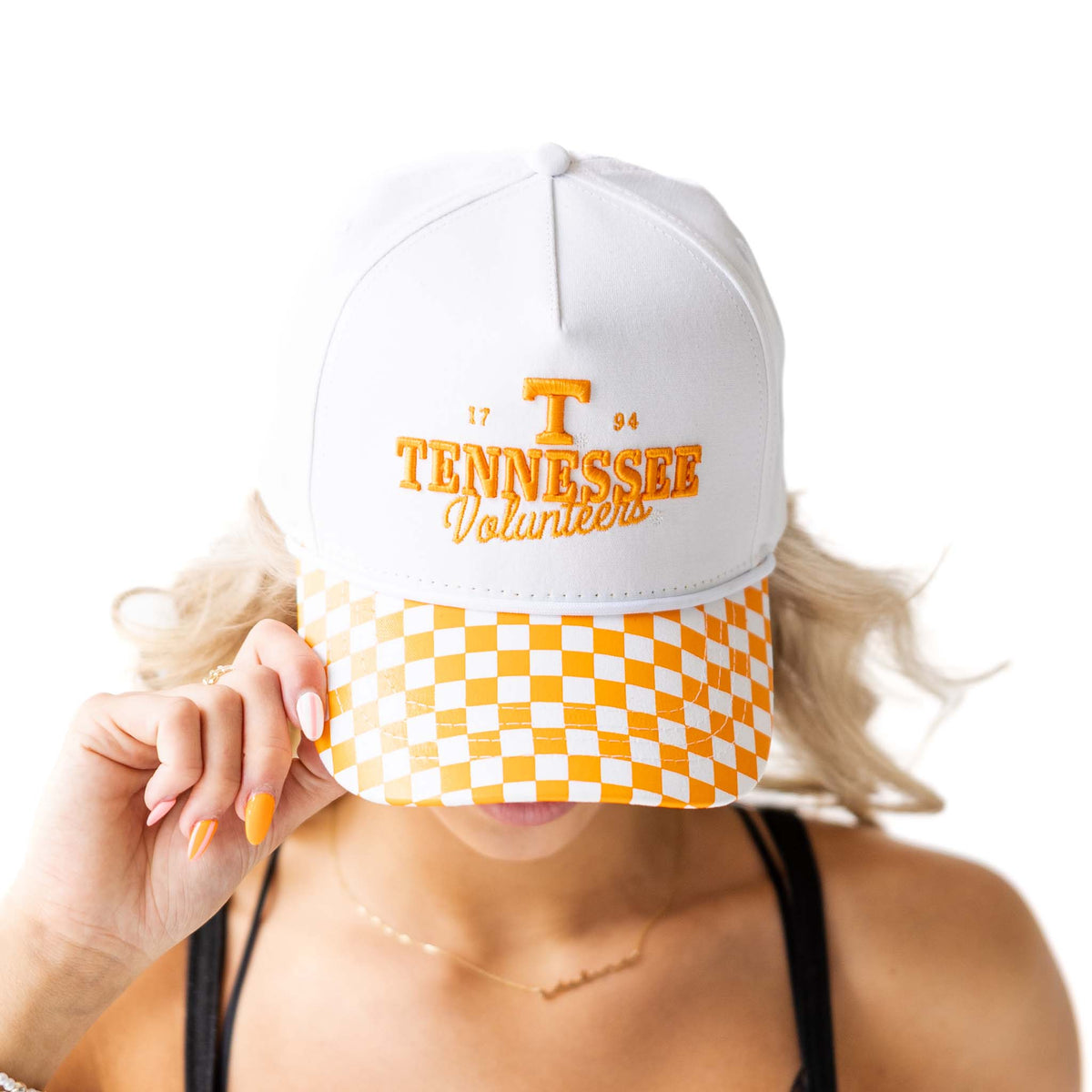 Tennessee Volunteers white hat with orange embroidered logo and text, featuring an orange-and-white checkerboard bill, shown on model from front angle.