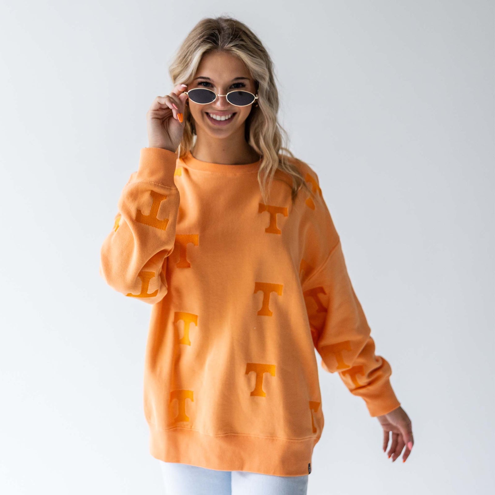 Tennessee Volunteers orange crewneck sweatshirt with allover tonal "T" pattern, modeled front view with sunglasses.