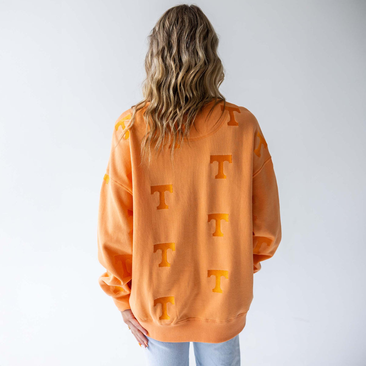 Back view of Tennessee Volunteers orange crewneck sweatshirt with repeating tonal "T" pattern.