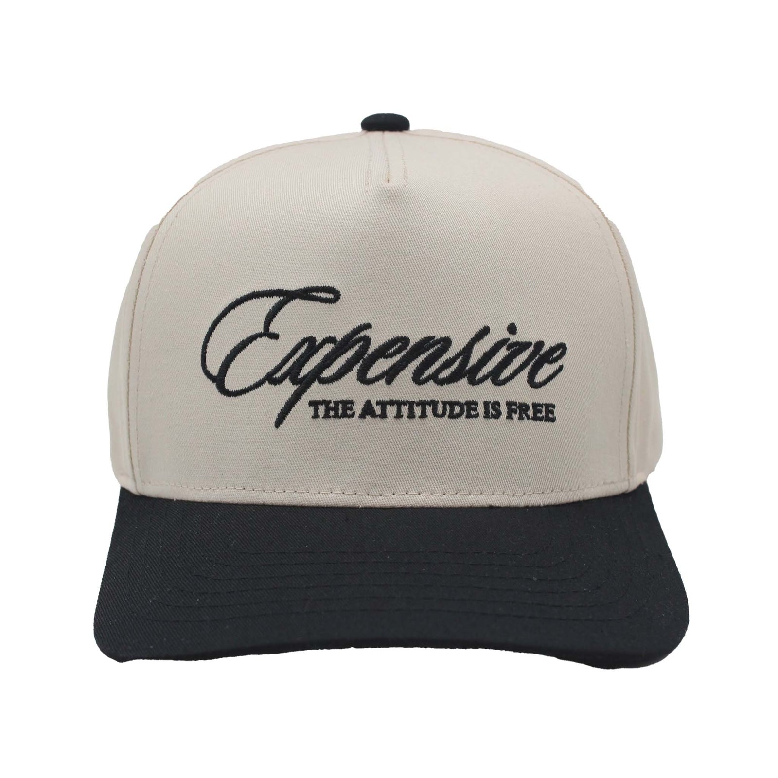 Two-tone trucker hat with natural crown and black bill featuring embroidered text 'Expensive – The Attitude Is Free' on the front panel.