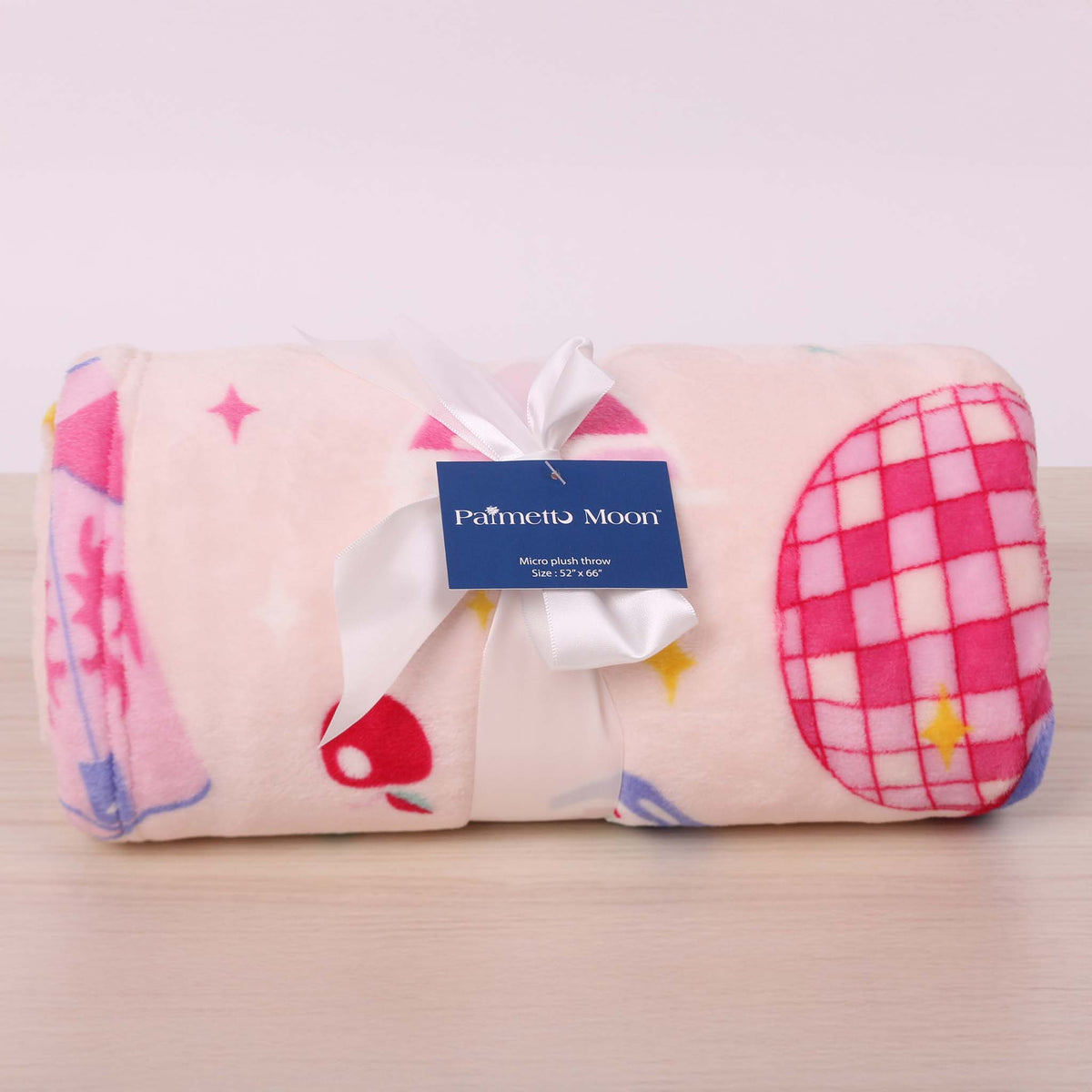 Disco cowgirl theme printed blanket shown rolled up and tied with a bow.